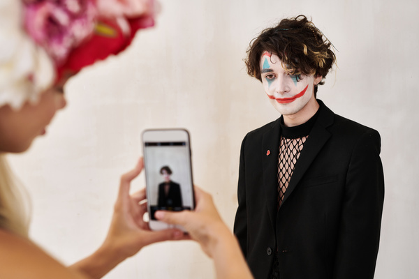 Woman with Wreath of Peonies Takes Pictures of Man with Joker Makeup